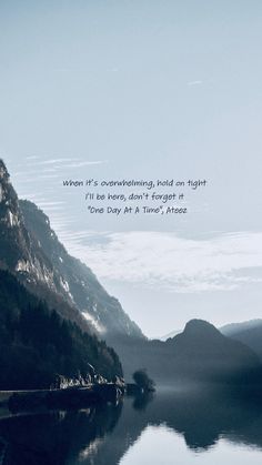 a lake with mountains in the background and a quote on it