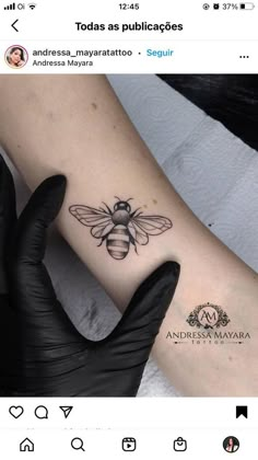 a woman's arm with a bee tattoo on it