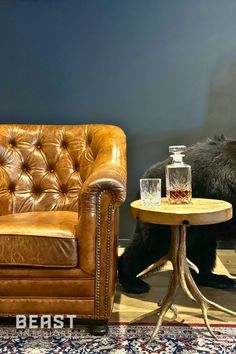 a brown leather chair sitting next to a table with a glass on top of it