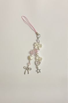 a pink ribbon with charms attached to it