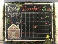 a chalkboard with a christmas calendar on it next to a small house and tree