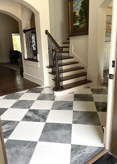 an entry way with stairs and checkered flooring