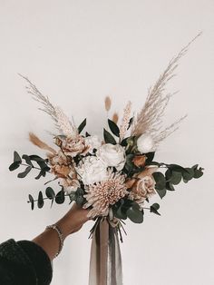 a person holding a bouquet of flowers in their hand