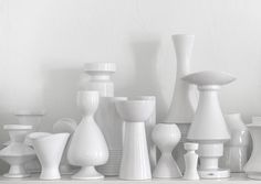 black and white photograph of many vases on display in a room with no one around