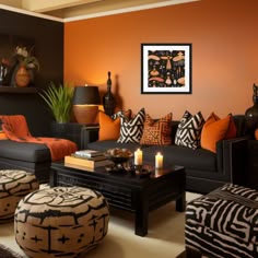 an orange and black living room with zebra print pillows on the couches, ottomans and coffee table