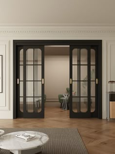 an empty living room with black french doors