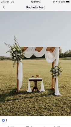 an outdoor ceremony setup with white draping and greenery on the sidelines