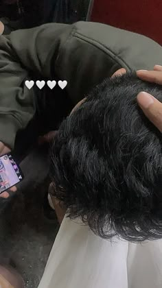 the man is getting his hair cut at the barbershop with two hearts drawn on them