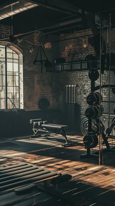 an empty gym room with benches and exercise equipment in the sun shining on the floor