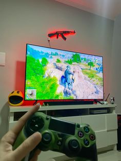 a person holding a video game controller in front of a tv with an image on it