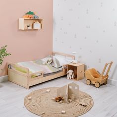 a child's bedroom with pink walls and wooden furniture, including a small bed