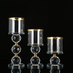 three clear glass candlesticks with gold trim