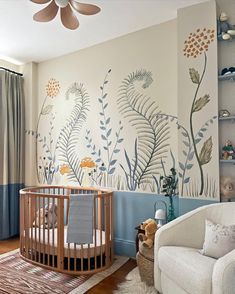 a baby's room decorated in blue, white and brown with flowers on the wall