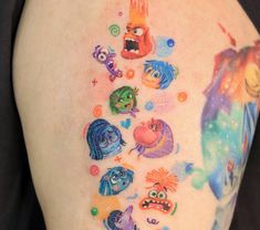 the back of a woman's shoulder with cartoon characters on her arm and chest