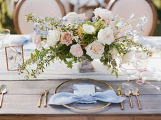 the table is set with flowers and silverware