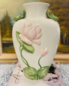 a white vase with pink flowers painted on it