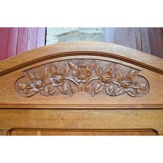 an ornate carved wooden headboard with flowers on it