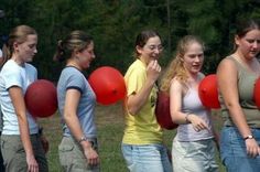 a group of young women standing next to each other with red balloons in front of them