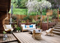 a wooden deck with chairs and couches on it