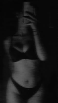 a blurry photo of a woman's stomach in black and white, with her hand on her head