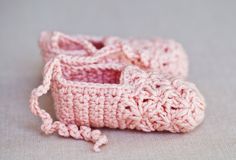 a pair of crocheted baby shoes sitting on top of a table