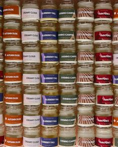 many jars are stacked on top of each other with different labels in front of them