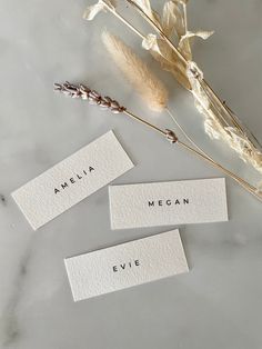 three place cards with the names of different types of flowers and leaves on them, sitting next to each other