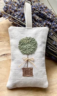 a small bag with a tree on it and some lavenders in the back ground