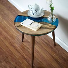 a table with a book, tea pot and vase on it