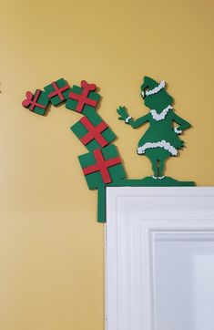 a paper cut out of a person on top of a door with a christmas tree