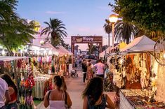 people are walking through an outdoor market area