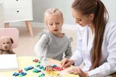 a woman and child playing with magnets on a table