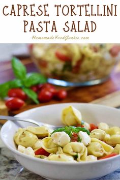 a white bowl filled with tortelli pasta and garnished with basil