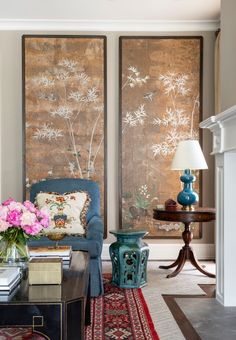 a living room filled with furniture and paintings on the wall