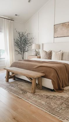 a bedroom with a bed, bench and window in the corner that overlooks an outdoor deck