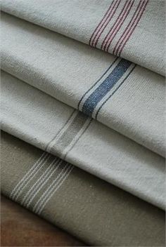 four folded linens are stacked on top of each other in different colors and patterns