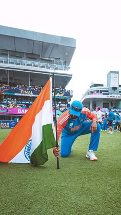 a man kneeling down next to a flag on top of a field