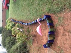 a pink flamingo standing in the middle of some blue jars