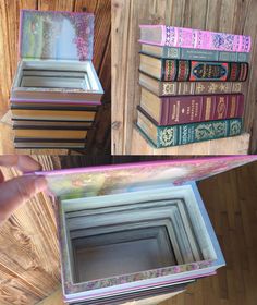 a person holding a book in front of some books on a wooden table with one open and the other closed