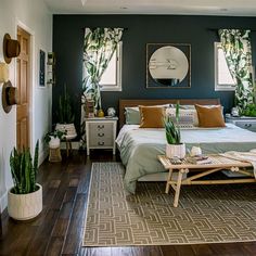 a bed room with a neatly made bed next to two windows and a rug on the floor