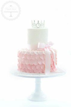 a white cake with pink ruffles and a crown on top