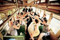 a group of people sitting on top of a green bench next to each other in front of windows