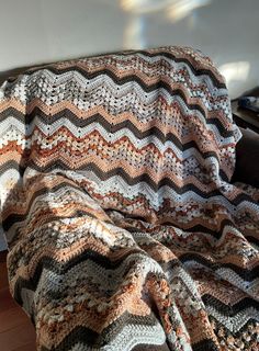 a crocheted blanket sitting on top of a couch