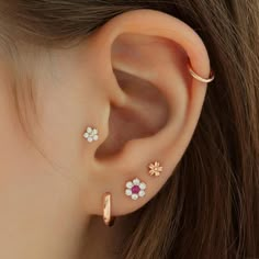 a woman's ear with three small flowers on it