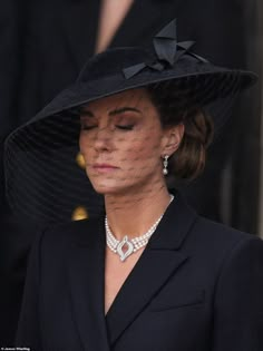 a woman wearing a black hat with a veil on her head and diamond necklaces