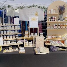 the table is full of different types of items for sale at the market stall, including soaps and lotions