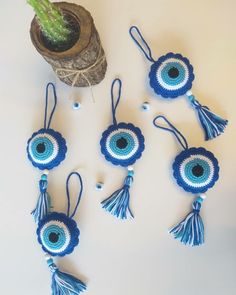 blue and white crocheted ornaments with tassels hanging from the side on a table