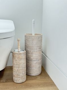 two baskets sitting on the floor next to a toilet