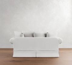 a white couch sitting on top of a wooden floor