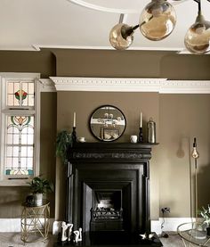 a living room filled with furniture and a fire place in front of a mirror on the wall